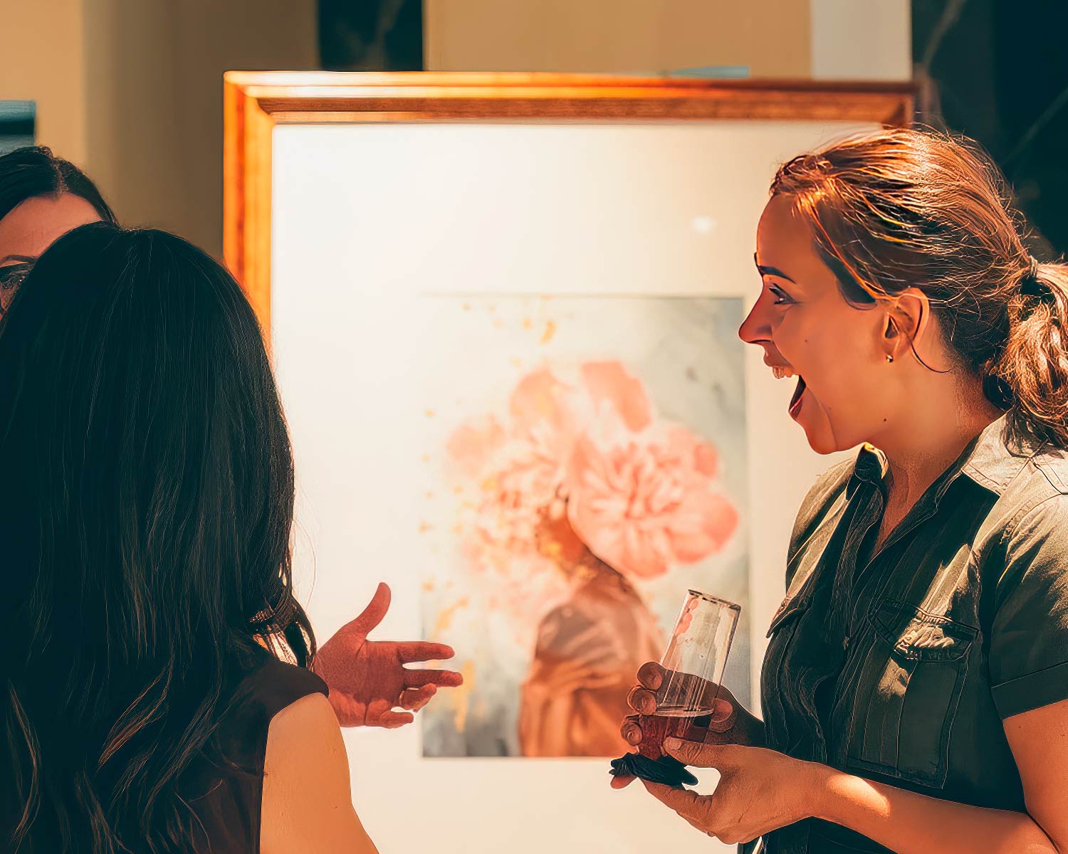 crowded gallery with people admiring watercolor paintings hanging on the walls. The artist, Alex Righetto, is standing in the foreground, smiling at the visitors.