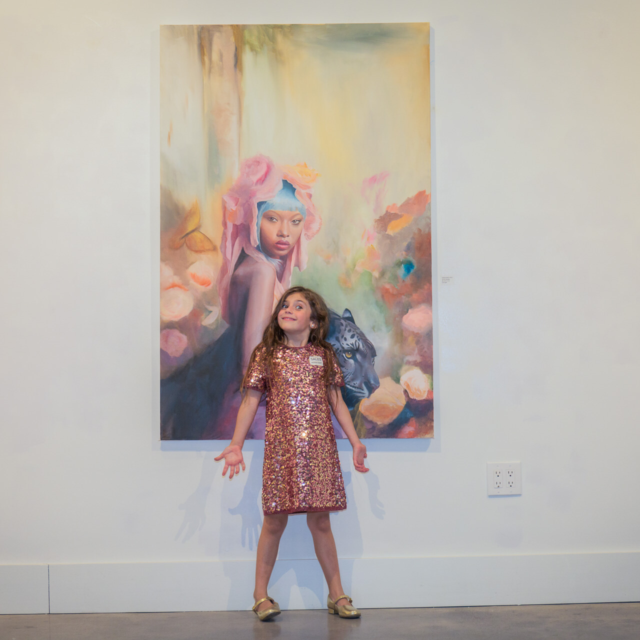 A delightful young visitor eagerly poses for a selfie with the 'Resilience' painting