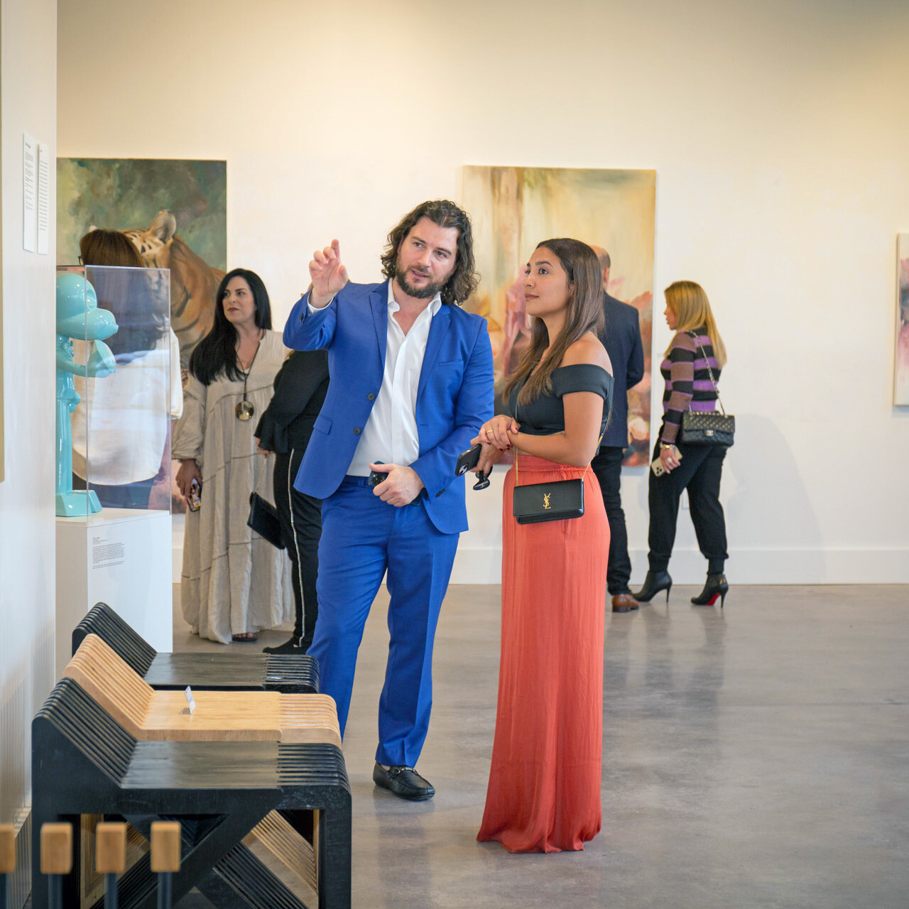 Artist Alex Righetto showing a painting titled 'Mona Lisa's Daughter' to an art collector in a gallery setting