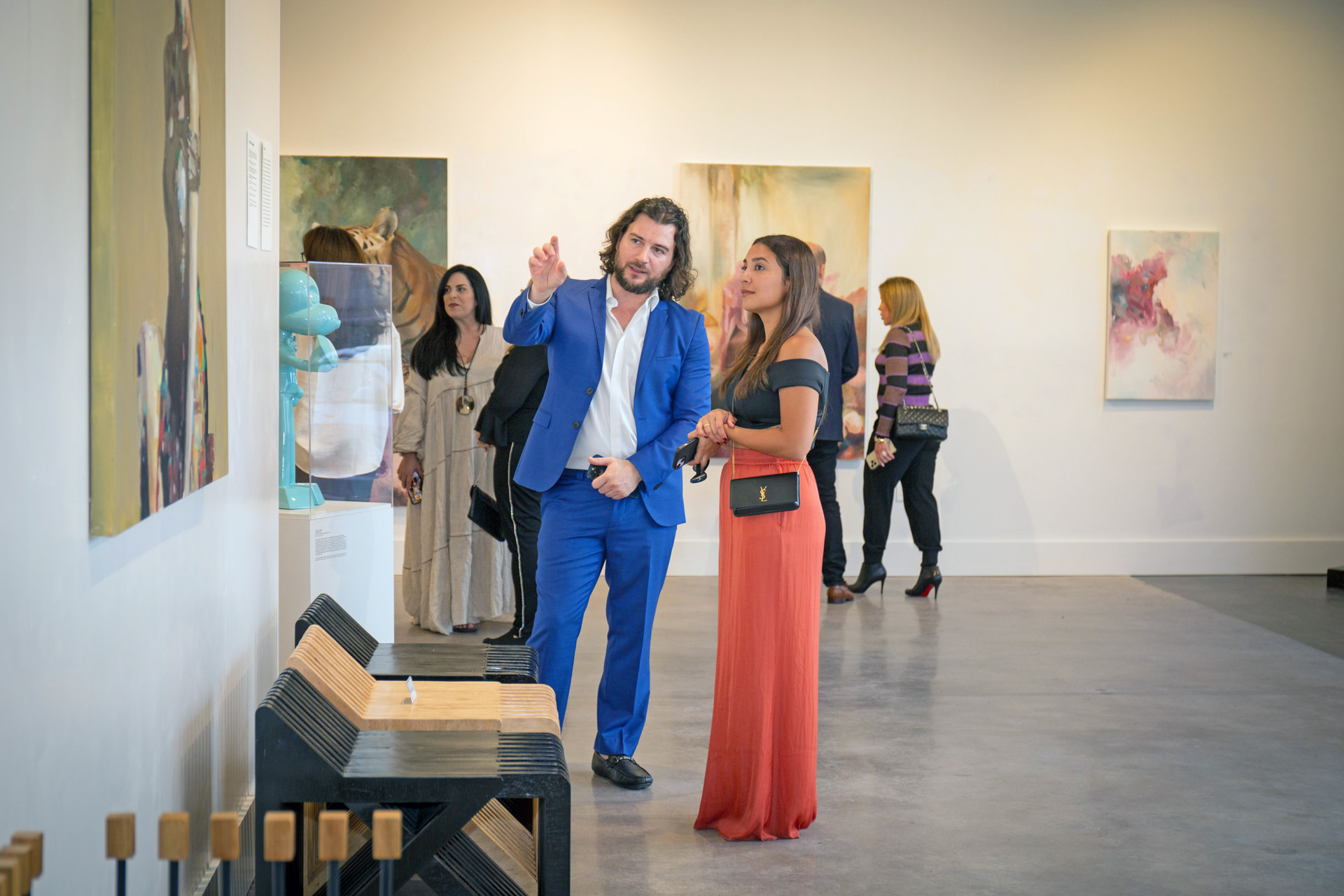 Artist Alex Righetto showing a painting titled 'Mona Lisa's Daughter' to an art collector in a gallery setting