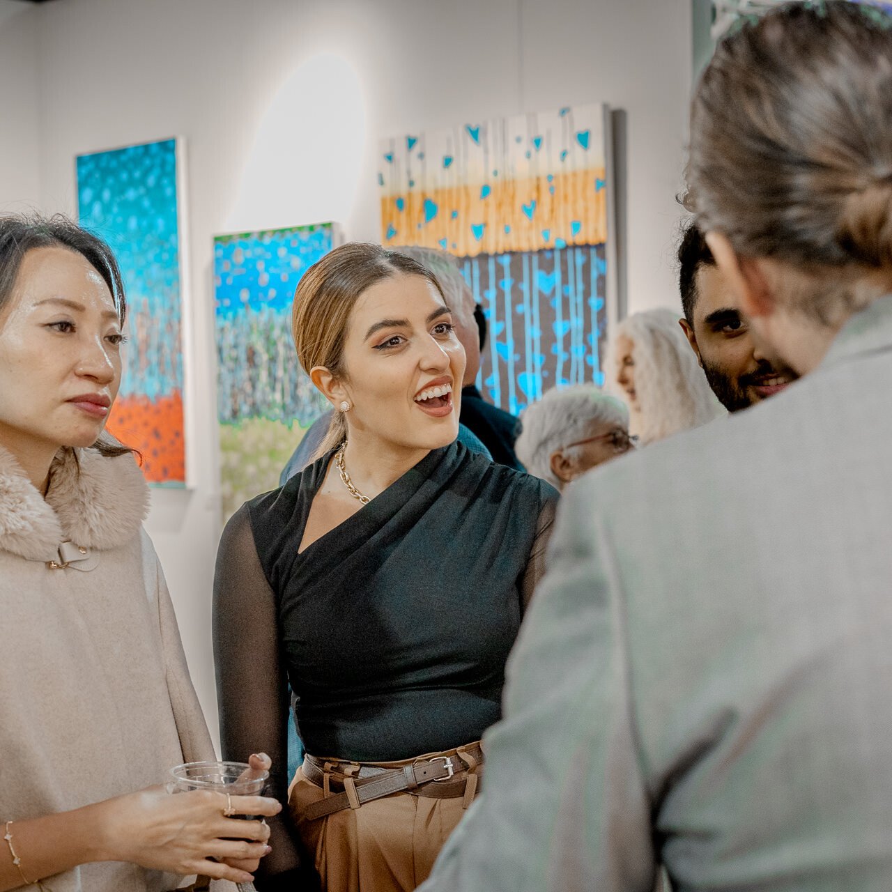 A woman in awe, with her hand on her chest, looks intently at 'The Guardian' painting by Alex Righetto, which addresses the issue of human trafficking through powerful visual storytelling.