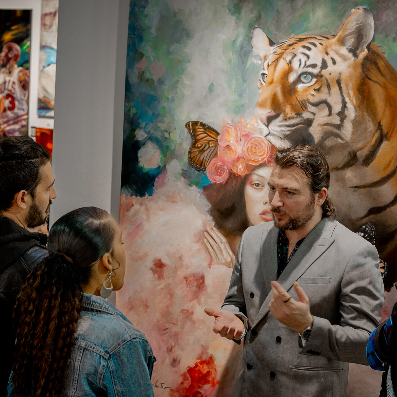 Alex Righetto gesturing while talking to fairgoers about his artwork 'The Guardian' at the Spectrum Miami art fair.
