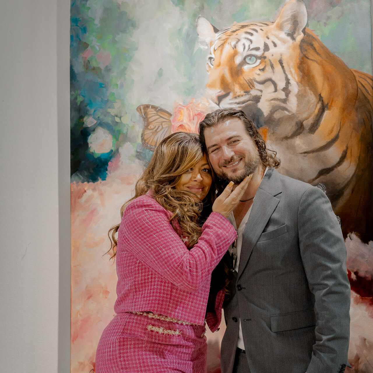 Stacy Francis and Alex Righetto stand together in front of Righetto's painting 'The Guardian,' an evocative piece from his Radiance Collection advocating against human trafficking.