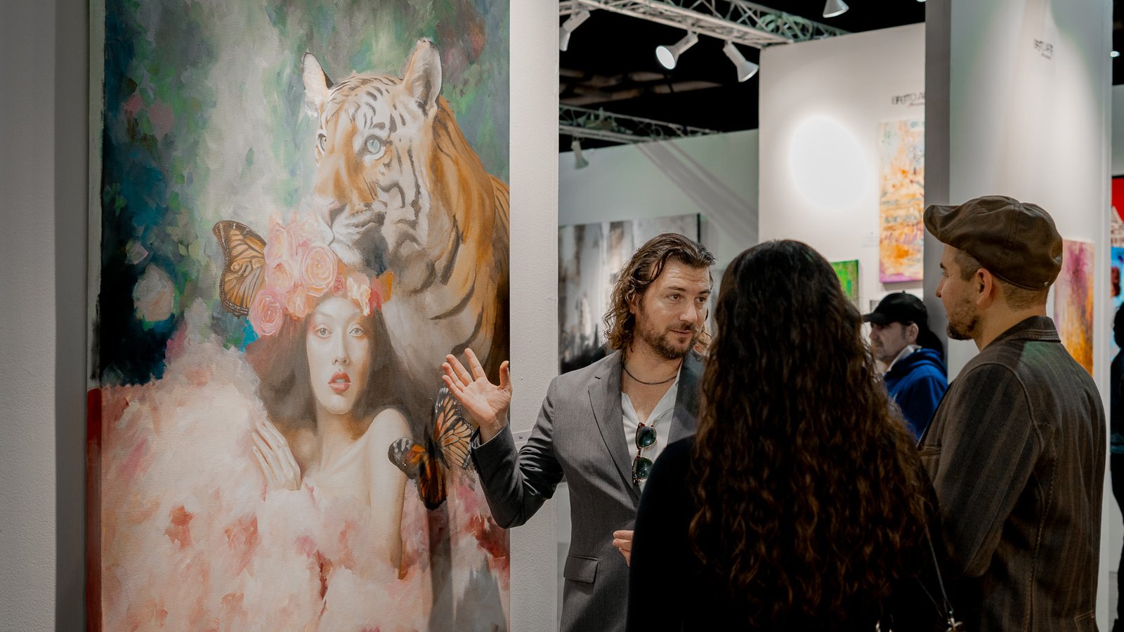 Alex Righetto explains the inspiration behind 'The Guardian' to an attentive audience at an art exhibition.