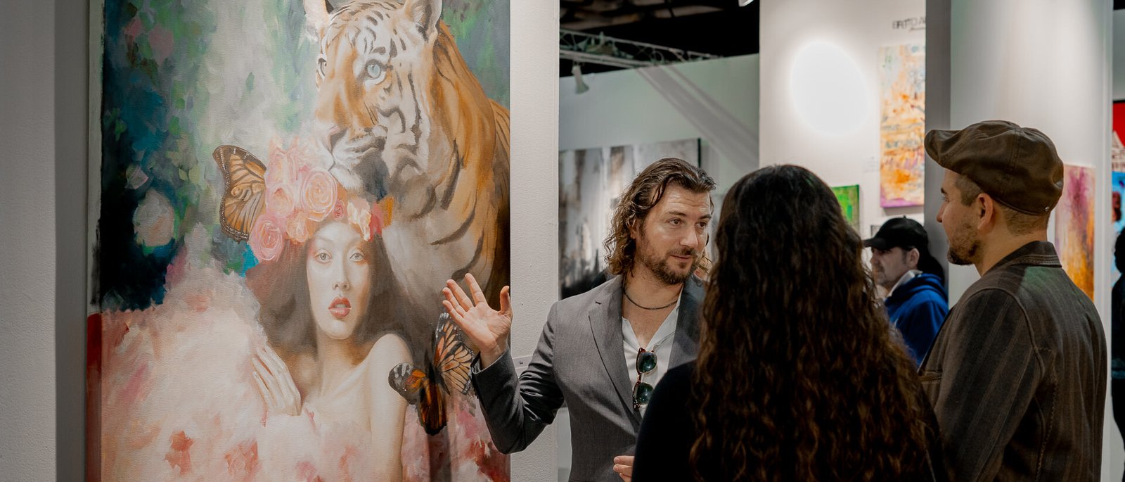 Alex Righetto explains the inspiration behind 'The Guardian' to an attentive audience at an art exhibition.