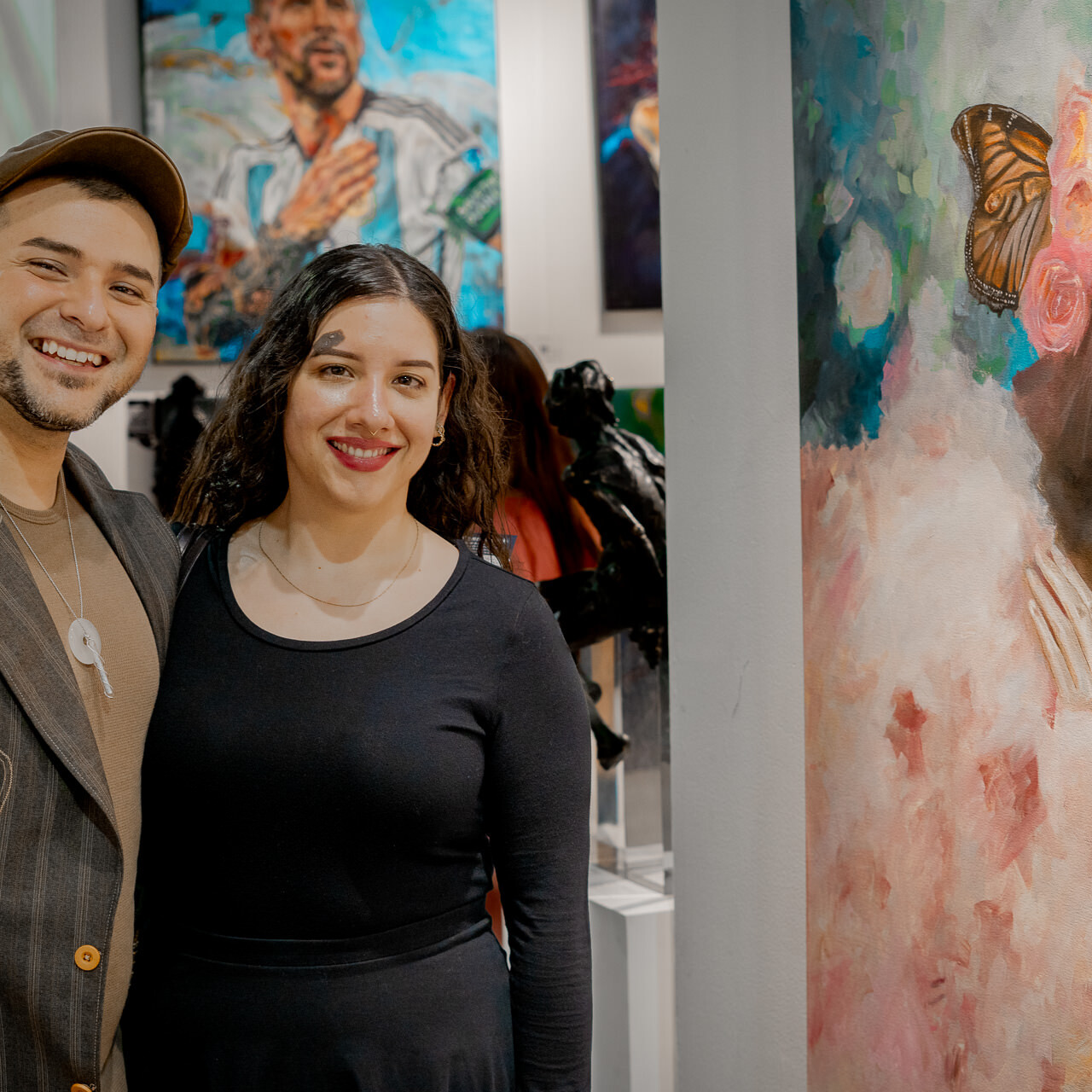 Two art collectors stand next to Alex Righetto's painting 'The Guardian' at Spectrum Miami 2023