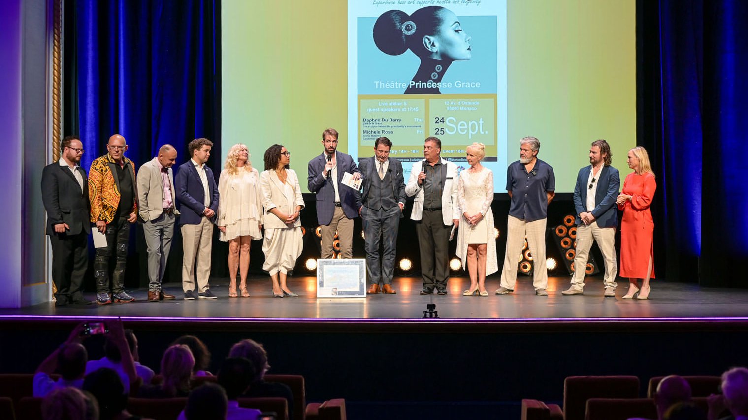 Alex Righetto on stage at Art & Luxury Monaco 2026 with Princess Margherita de Bourbon de Parme and event organizer Annette at the Théâtre Princesse Grace.